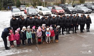 dzieci i policjanci na placu Szkoły Policji