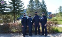 Słuchacze Szkoły Policji w maseczkach na twarzy. W tle Szpital Specjalistyczny w Pile.