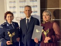 Komendant Szkoły Policji w mundurze stoi w towarzystwie mężczyzny i kobiety na wspólnym zdjęciu laureatów plebiscytu Osobowość roku 2020.