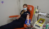 Policjantka w pozycji pół siedzącej podczas pobierania krwi.