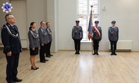 Pani Zastępca Szkoły Policji wraz z kierownikami zakładów i wydziałów Szkoły w umundurowaniu galowym. W tle Poczet Sztandarowy wraz ze Sztandarem Szkoły Policji w Pile.