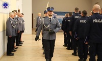 Maszerujący policjanci Pocztu Sztandarowego Szkoły Policji przechodzą obok umundurowanych policjantów absolwentów kursu.