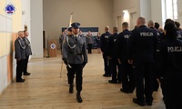 Poczet sztandarowy opuszczający aulę Szkoły Policji w Pile po uroczystym rozpoczęciu kursu