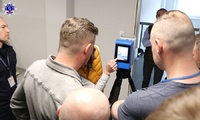 Uczestnicy szkolenia sprawdzają, jak działa skaner 3D, patrząc na ekran skanera