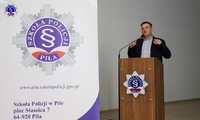 Mężczyzna stojący przy mównicy z mikrofonem