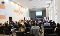 Uczestnicy konferencji siedzący na krzesłach podczas wykładu