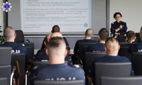 Umundurowani policjanci słuchający wykładu prowadzącej policjantki.