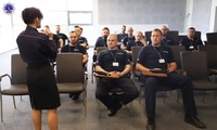 Umundurowana policjantka prowadzi wykład dla policjantów.