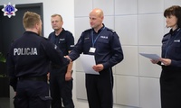 Zastępca Komendanta Szkoły Policji w Pile wręcza w auli akademika policjantowi świadectwo w obecności przedstawicieli kardy dydaktycznej.