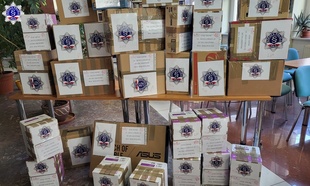 Przygotowane dary zapakowane w kartonach z logo Szkoły Policji w Pile.