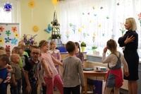 Podkom. Magdalena Pałys rozmawia z przedszkolakami. Wszyscy stoją.