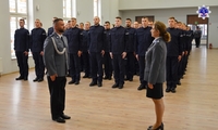 Pani Zastępca Komendanta Szkoły Policji w Pile przyjmuje meldunek od umundurowanego policjanta. W tle stoją słuchacze Szkoły Policji w Pile.