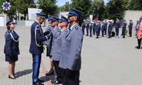 Zastępca komendanta Głównego Policji przypina odznakę wyróżnionemu policjantowi.