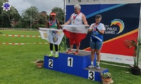 Finalistki Światowych Igrzysk Policjantów i Strażaków Rotterdam 2022 na podium ze zdobytymi medalami, trzymają w ręku swoje narodowe flagi