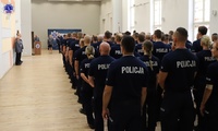 Widok z tyłu umundurowanych policjantów – słuchaczy szkolenia zawodowego podstawowego podczas uroczystego rozpoczęcia szkolenia na auli Szkoły Policji w Pile