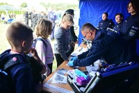 Podkom. Jacek Cyran – technik kryminalistyki ze Szkoły Policji w Pile robiący dzieciom odbitki linii papilarnych.