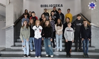 Zdjęcie grupowe uczniów na tle Biblioteki Szkoły Policji w Pile.