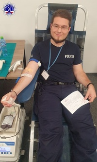 Umundurowany funkcjonariusz podczas oddawania krwi.