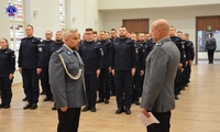 Zastępca Komendanta Szkoły Policji w Pile przyjmuje meldunek od umundurowanego policjanta. W tle słuchacze Szkoły Policji w Pile.