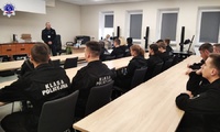 Umundurowani uczniowie klas policyjnych siedzący w ławkach w sali dydaktycznej podczas spotkania z podkom. Arturem Pinkowskim – technikiem kryminalistyki ze Szkoły Policji w Pile