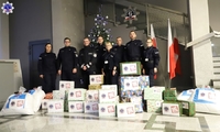 Umundurowani policjantki i policjanci z przygotowanymi prezentami.