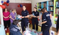 Przedstawiciele szkolnego samorządu podczas przekazywania darów dla dzieci w pilskim szpitalu. Na zdjęciu pracownicy szpitala i umundurowani policjanci.