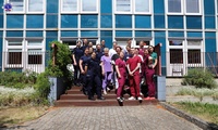 Zdjęcie grupowe przedstawicieli szkolnego samorządu oraz personelu szpitala przed budynkiem pilskiego szpitala
