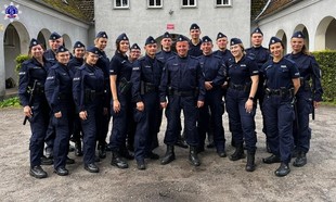 Zdjęcie grupowe policjantów na dziedzińcu zabezpieczających Festiwal Pol’and’Rock