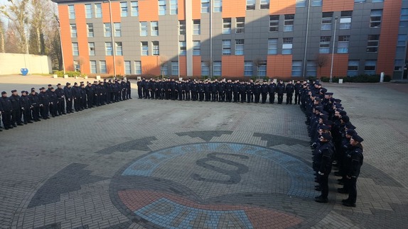 Zdjęcie kolorowe, policjanci stoją na placu apelowym Szkoły Policji w Pile przed rozpoczęciem kursu specjalistycznego