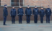 Zdjęcie kolorowe, policjanci umundurowani - kadra Szkoły Policji w Pile stoją w trakcie uroczystej zbiórki