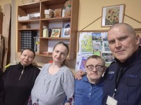 wspólna fotografia podopiecznych Warsztatów Terapii Zajęciowej z komisarzem Wojciechem Kurem.