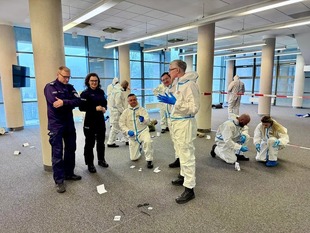 zespół techników kryminalistyki w kombinezonach ochronnych