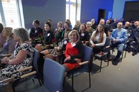 widok publiczności siedzącej na auli Szkoły Policji