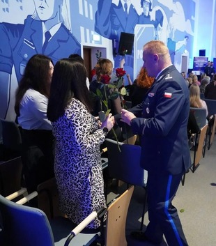 Komendant Szkoły Policji w Pile inspektor doktor Mariusz Jaworski wręcza kwiaty kobietom