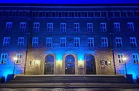 zdjęcie przedstawia front budynku Szkoły Policji w Pile oświetlony na kolor niebieski