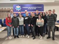 Grupa policjantów w ubiorze cywilnym uśmiecha się do zdjęcia grupowego.