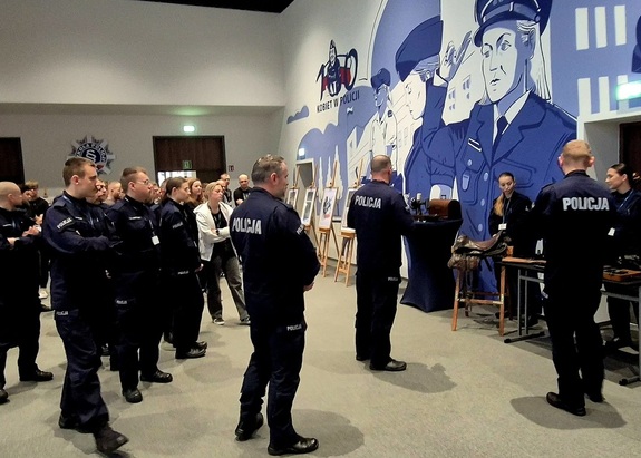 policjanci zapoznają się z ekspozycją prywatnej wystawy post. Grzegorza Augustyniaka.