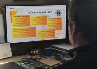 Policjant siedzi przed komputerem, zgłębia wiedze w kursie online.
