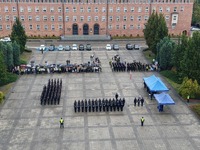 widok z lotu ptaka na szyk policyjny oraz zaproszonych gości na Placu Staszica w Pile - w tle widać front budynku Szkoły Policji w Pile
